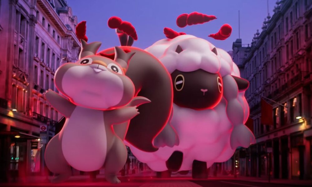 Zwei gigantische Pokémon mit rotem Schein wandern durch eine von Dämmerlicht erleuchtete Stadt. | © Pokémon GO / Screenshot YouTube