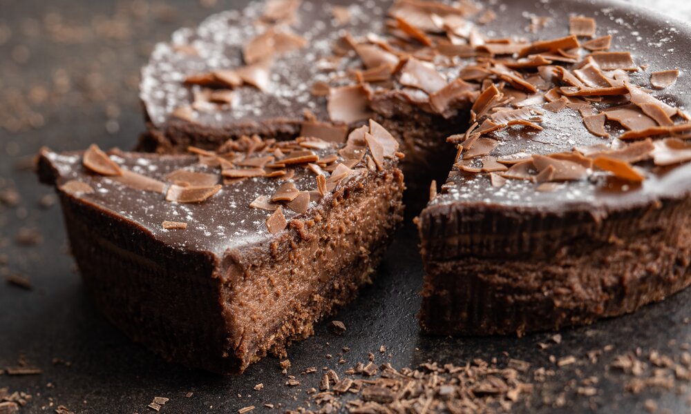 Angeschnittener Frischkäse-Schokokuchen mit einer Schokoglasur und Schokoraspeln on top. | © Adobe Stock / Jiri Hera