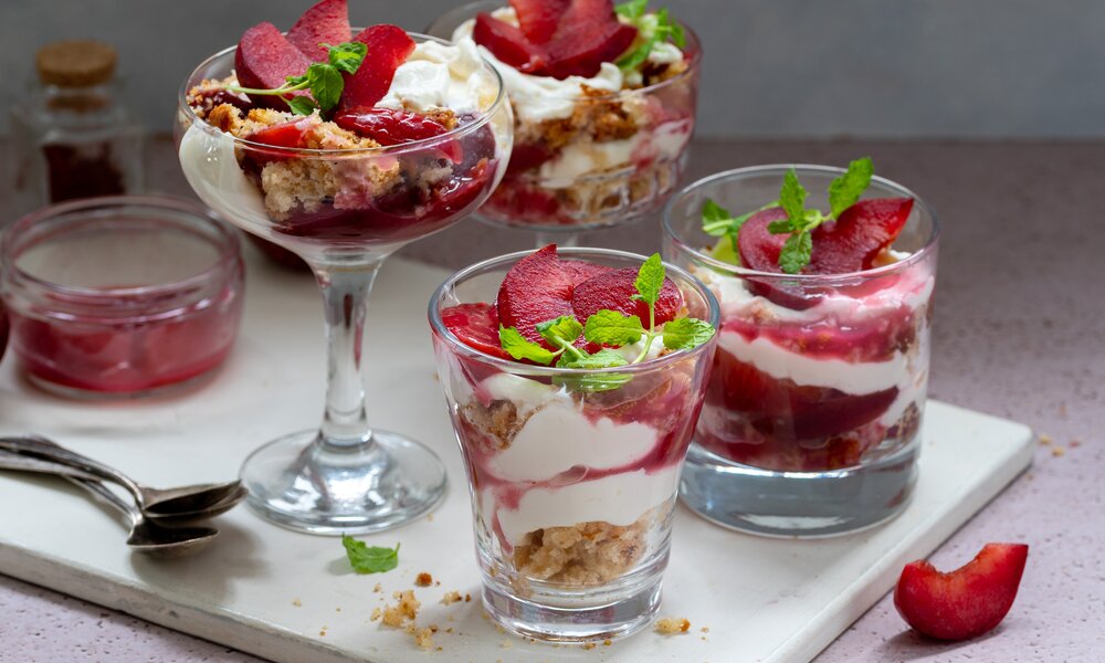 Mehrere verschiedene Gläser befüllt mit einem Pflaumen-Mascarpone-Schichtdessert. | © Adobe Stock / Inga