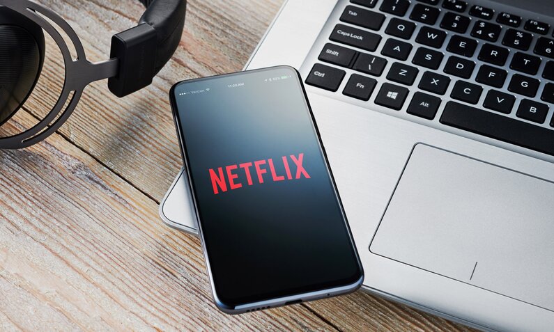Netflix-Logo auf Smartphonebildschirm und Laptop | © Getty Images/Future Publishing