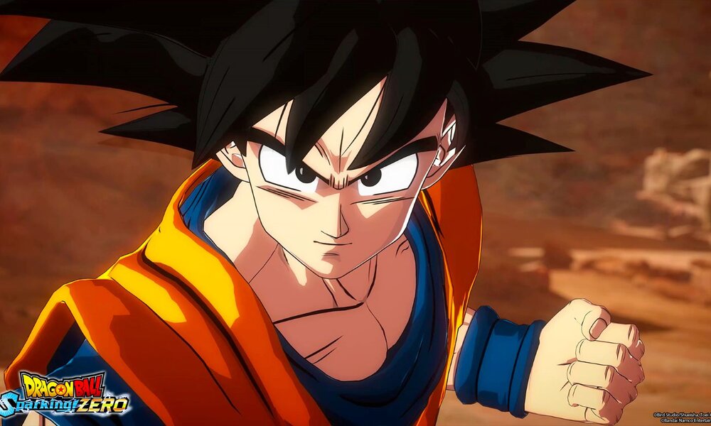 Ein junger Mann mit schwarzem, stacheligen Haar und entschlossenem Blick in orangefarbener Kampfkleidung ballt die Faust in einer Wüstenlandschaft. | © Bandai Namco