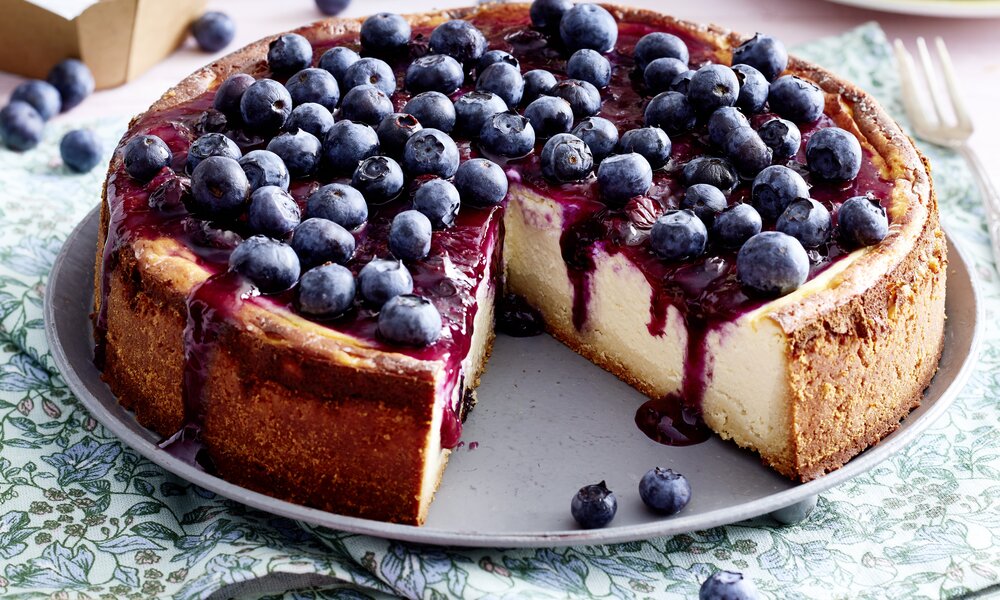 Angeschnittener Blaubeer-Käsekuchen auf einem Kuchenteller angerichtet. | © 	Isabell Triemer
