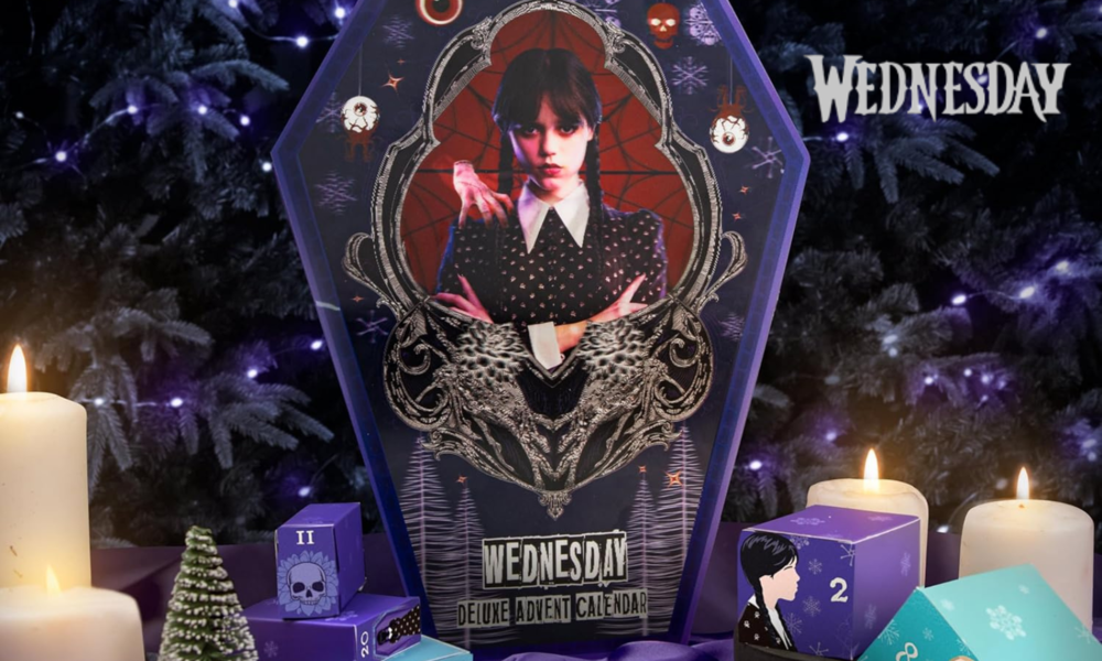 „Wednesday“-Adventskalender in Sargform mit einem düsteren Bild von Wednesday Addams, umgeben von brennenden Kerzen und violetten Geschenkschachteln mit Nummern darauf. | © Amazon/Cinereplicas