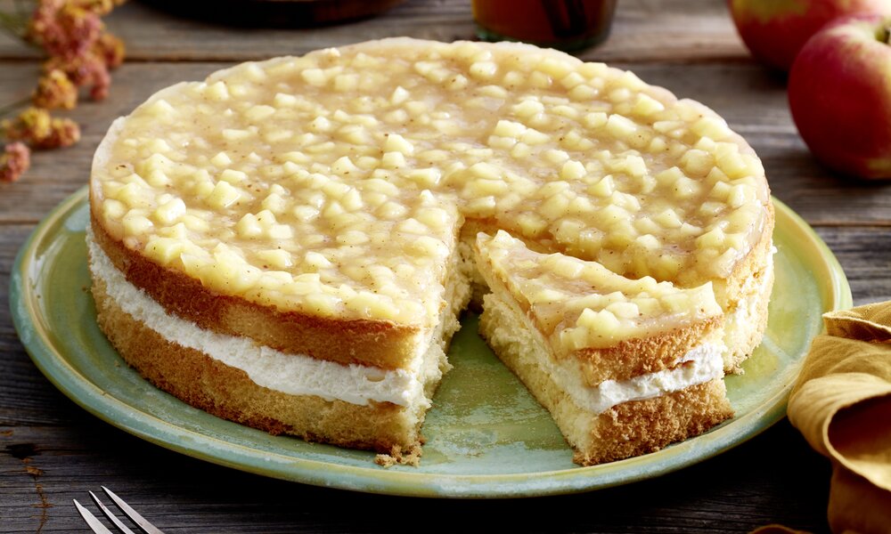 Apfel-Schmandkuchen in Nahaufnahme, oben auf dem Kuchen ein Apfel-Kompott-Spiegel, mit Cremefüllung und Biskuitboden. | ©  Isabell Triemer