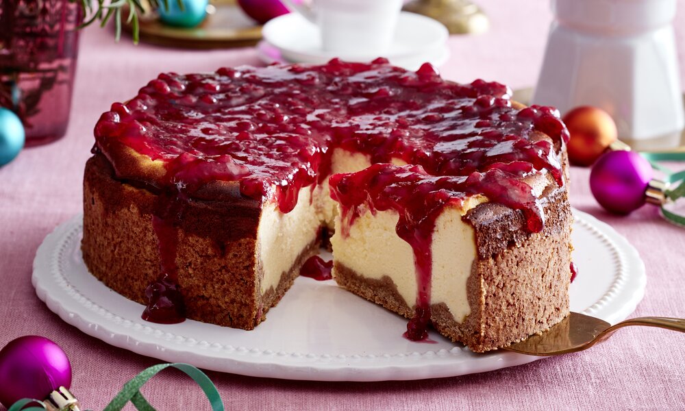 Angeschnittener Spekulatius- Käsekuchen mit Preiselbeer-Topping in weihnachtlicher Umgebung. | © Isabell Triemer