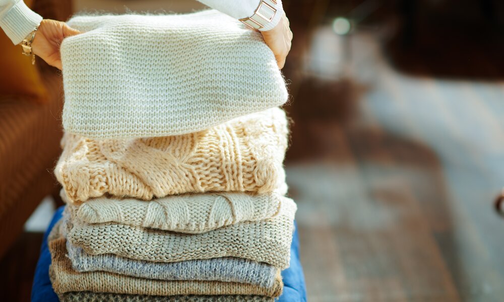 ein stapel mit warmen winterpullovern | © Adobe Stock/ Alliance