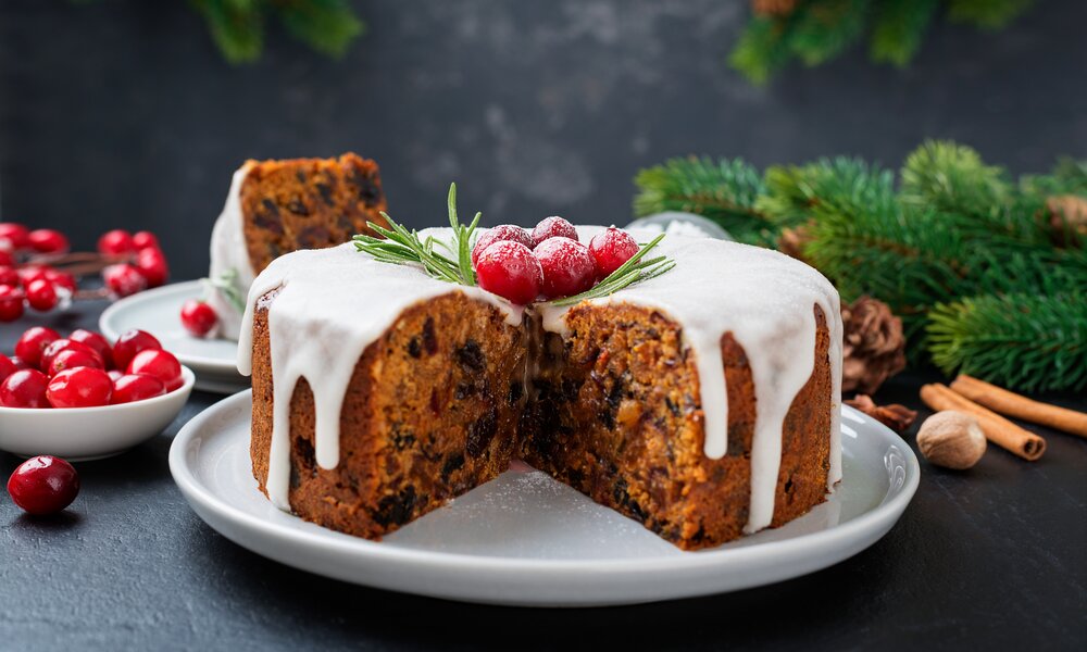 Angeschnittener weihnachtlicher Fruchtkuchen mit Frischkäseglasur on top. | © Adobe Stock / Nelea Reazanteva