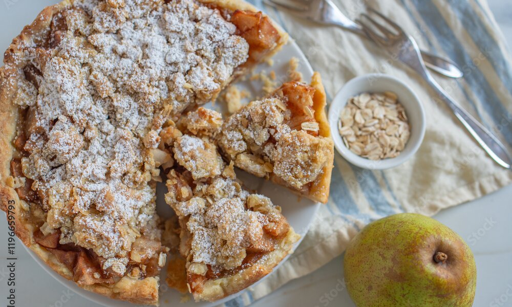 Angeschnittener Apfel-Streuselkuchen von Oben, daneben frische Äpfel. | © Adobe Stock / A_Lein