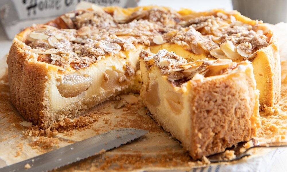 Angeschnittener Apfelkuchen auf einem Holztisch. | © Adobe Stock / Kerstin