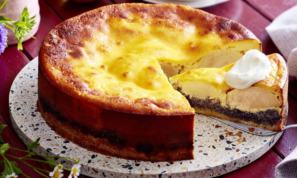 Angeschnittener Apfel-Schmandkuchen mit Mohnfüllung auf einem Kuchenteller. | © Isabell Triemer