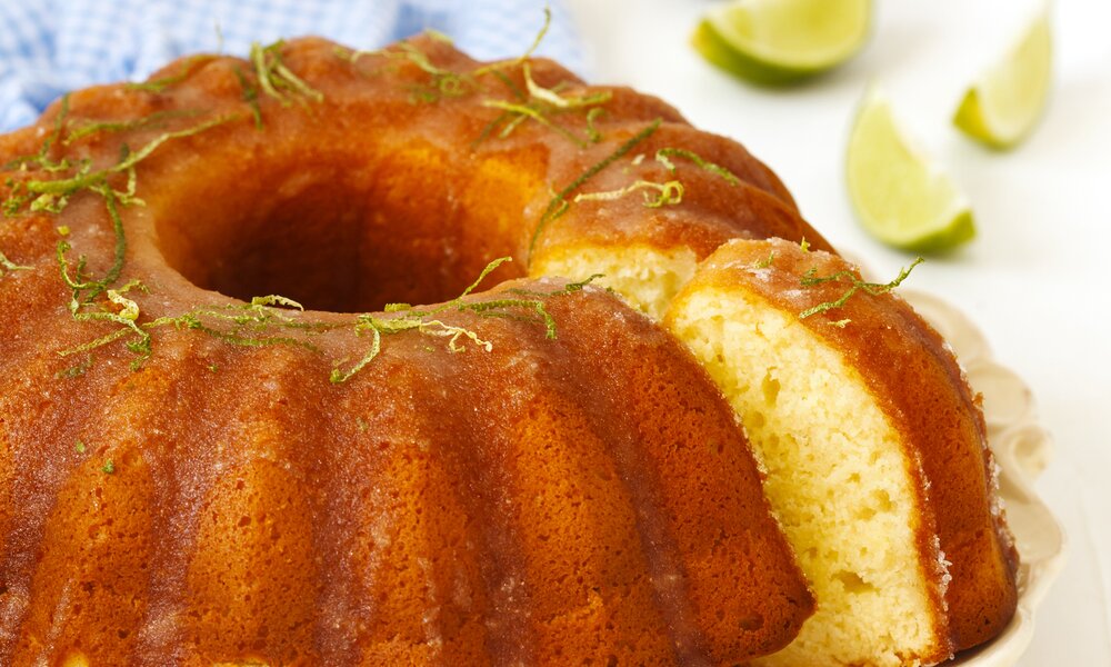 Angeschnittener Zitruskuchen mit Limettenstreifen garniert. | © Getty Images / AnjelaGr