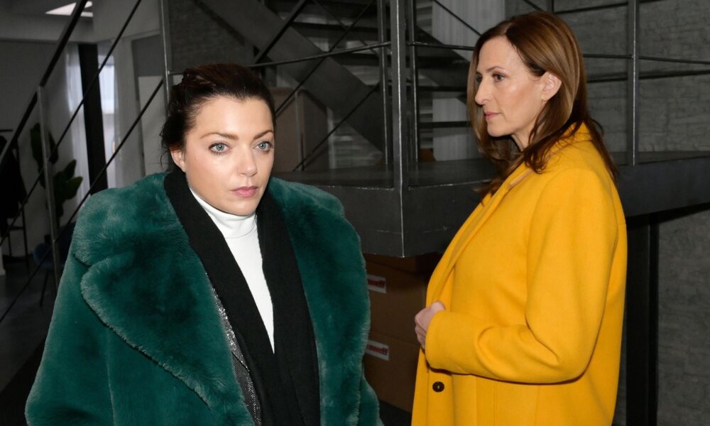 Zwei Frauen in eleganter Winterkleidung stehen in einem modernen Büro, die eine wirkt nachdenklich, die andere entschlossen.	 | © RTL / Rolf Baumgartner