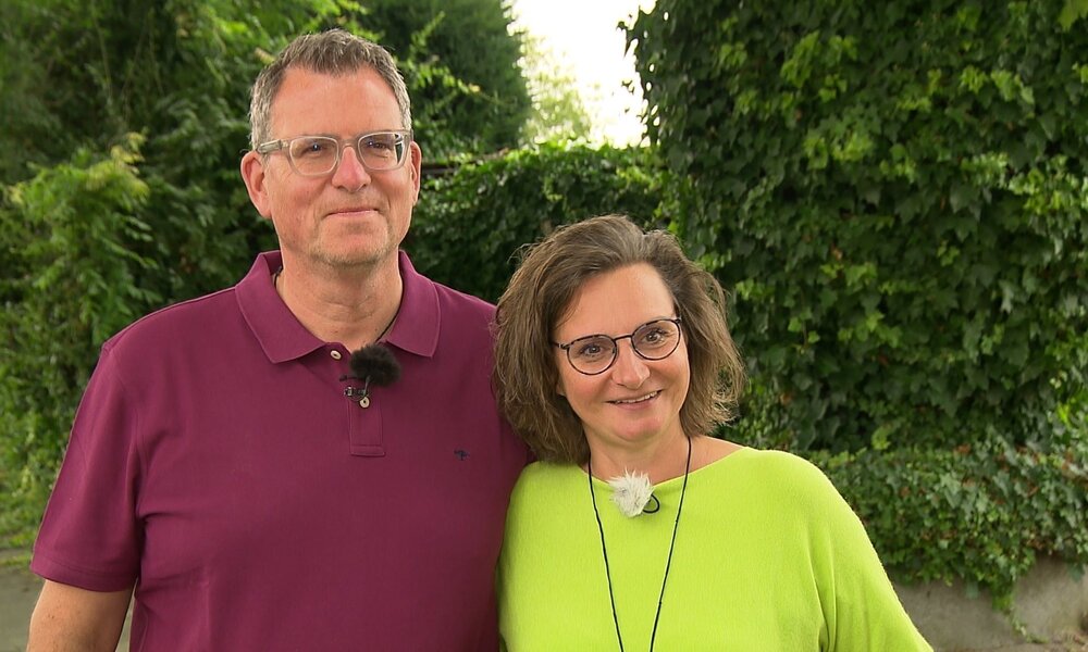 Ein Mann im bordeauxfarbenen Polohemd und eine Frau im limonengrünen Oberteil lächeln entspannt in die Kamera. | © ZDF/Gunther Weber