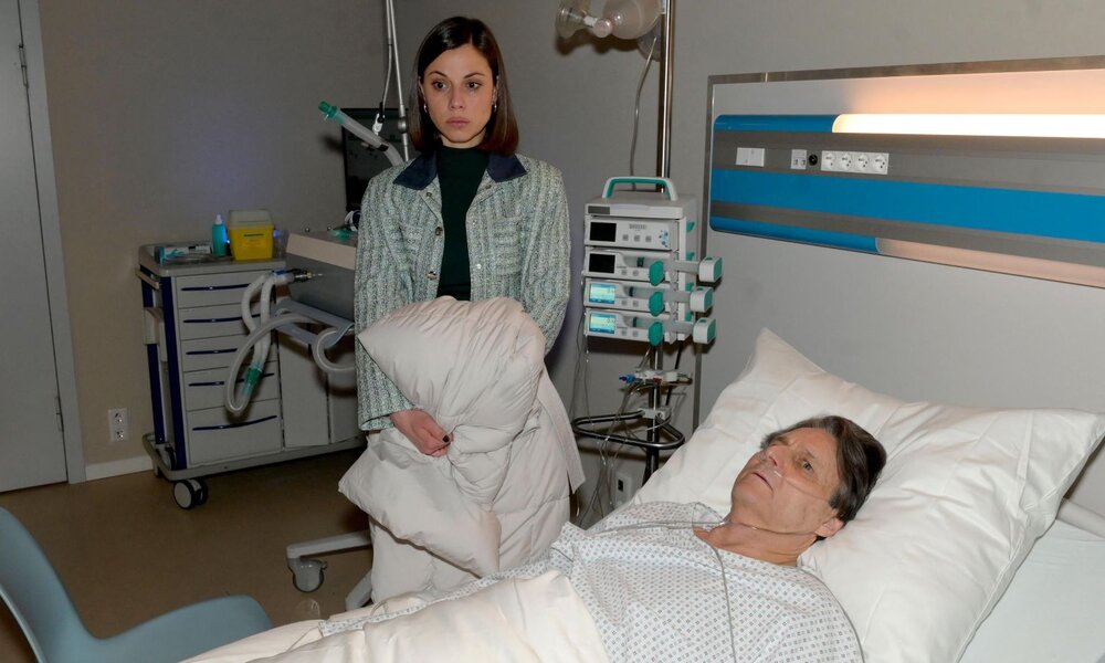Ein alter Mann mit Sauerstoffschlauch liegt in einem Krankenhausbett, während eine junge Frau mit besorgtem Blick daneben steht. | © RTL / Rolf Baumgartner