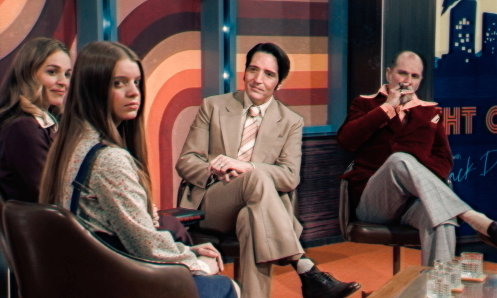 Ausschnitt aus dem Film "Late Night with the Devil"; Gäste sitzen in Talkshow-Setting | © IMAGO / Landmark Media