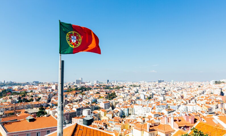 Portugalflagge, Lissabon im Hintergrund | © gettyimages / Alexander Spatari