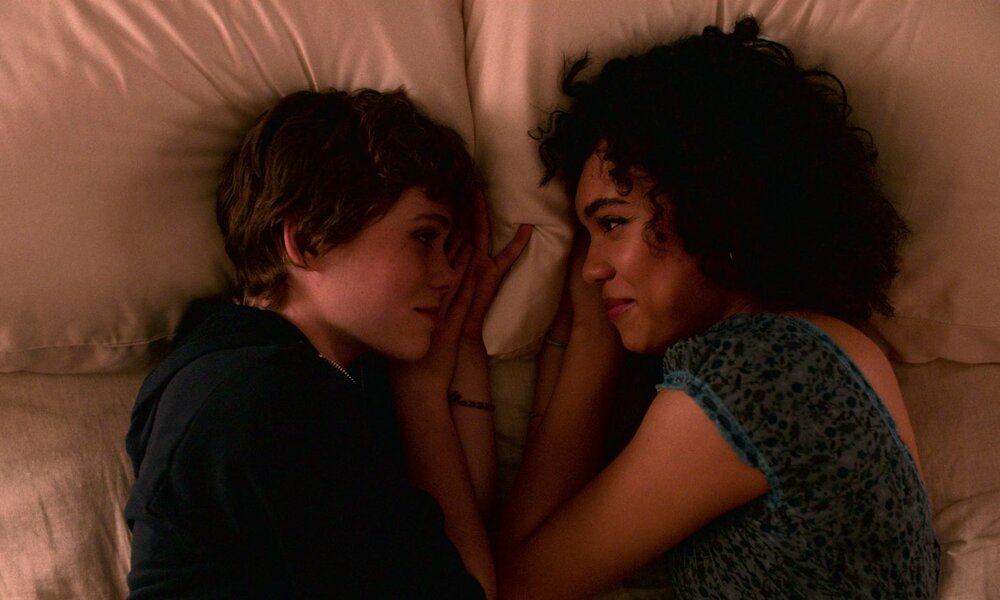 Zwei junge Frauen (Syd und Dina) liegen einander zugewandt auf einem Bett und blicken sich zärtlich und lächelnd in die Augen. | © Netflix