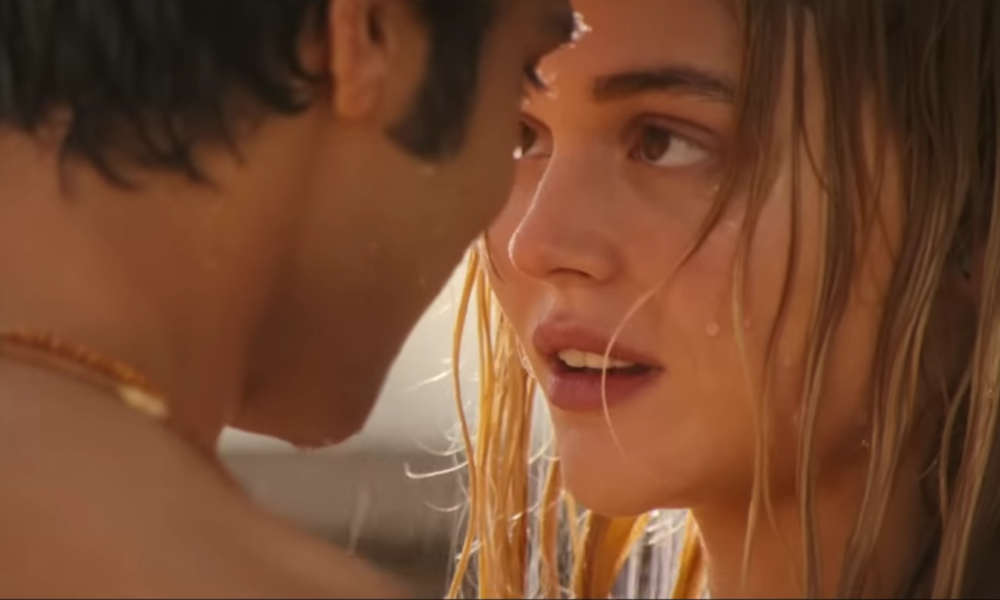 Junge Frau mit nassem, blondem Haar blickt emotional in die Augen eines jungen Mannes, beide stehen eng beieinander in warmem Licht. | © Amazon MGM Studios