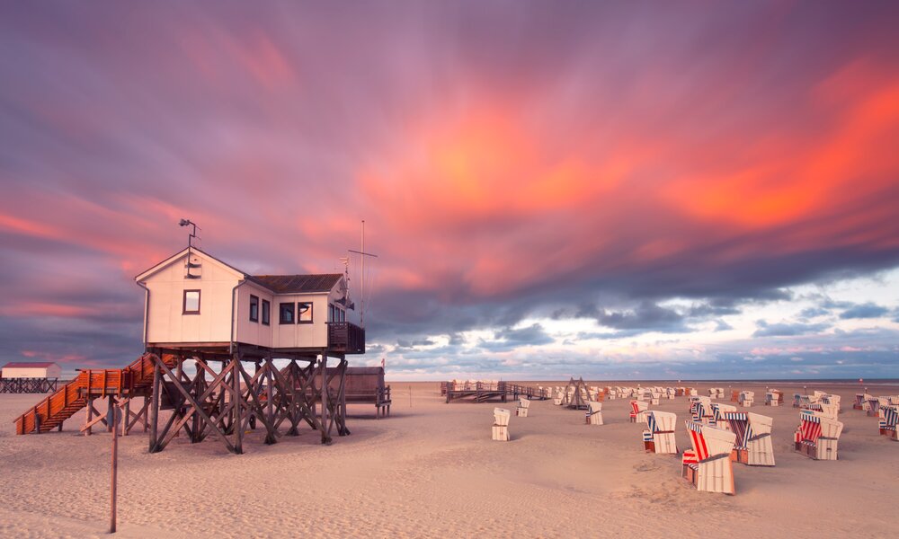 Strand und Pfahlbauten in St. Peter-Ording | © Adobe stock / Jenny Sturm