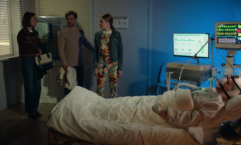 Ein Mann liegt bewusstlos mit Beatmungsgerät im Klinikbett, während drei Besucher betroffen im Türrahmen stehen. | © RTL