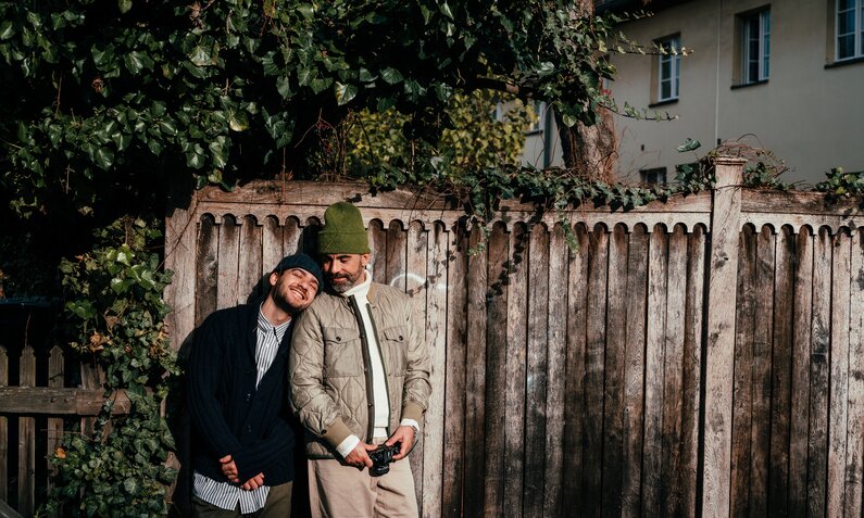 zwei Männer an Wand lehnend | © gettyimage / 	Alina Rudya/Bell Collective