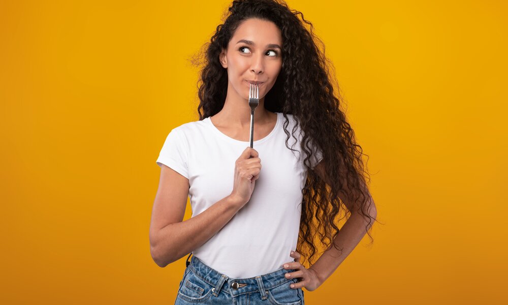 Frau mit Gabel im Mund | © Getty Images / Prostock-Studio