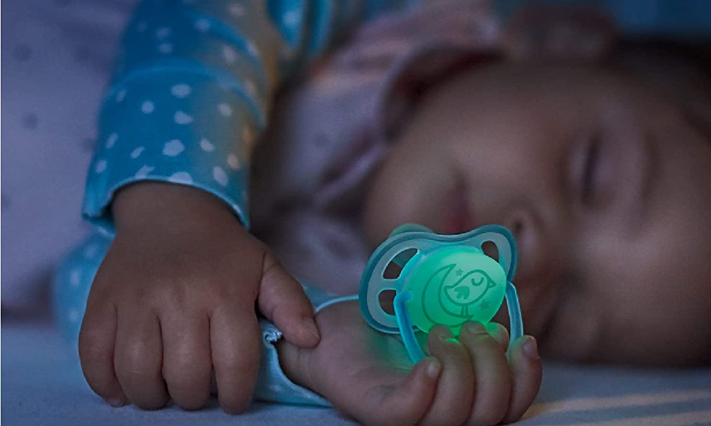Schlafendes Baby bei Nachtlicht mit leuchtendem Philips Avent-Schnuller | © Amazon