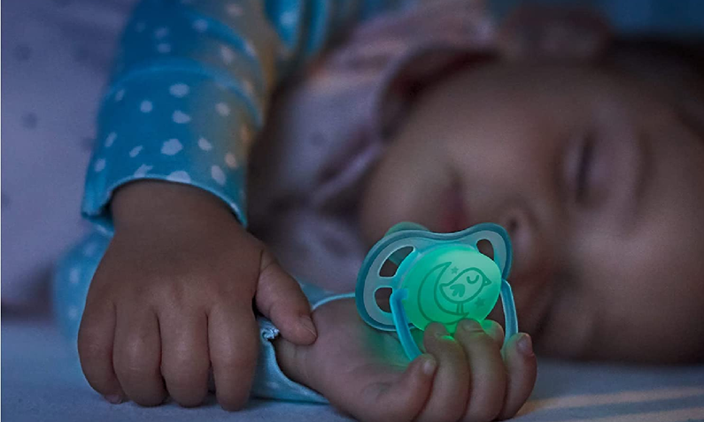 Schlafendes Baby bei Nachtlicht mit leuchtendem Philips Avent-Schnuller | © Amazon