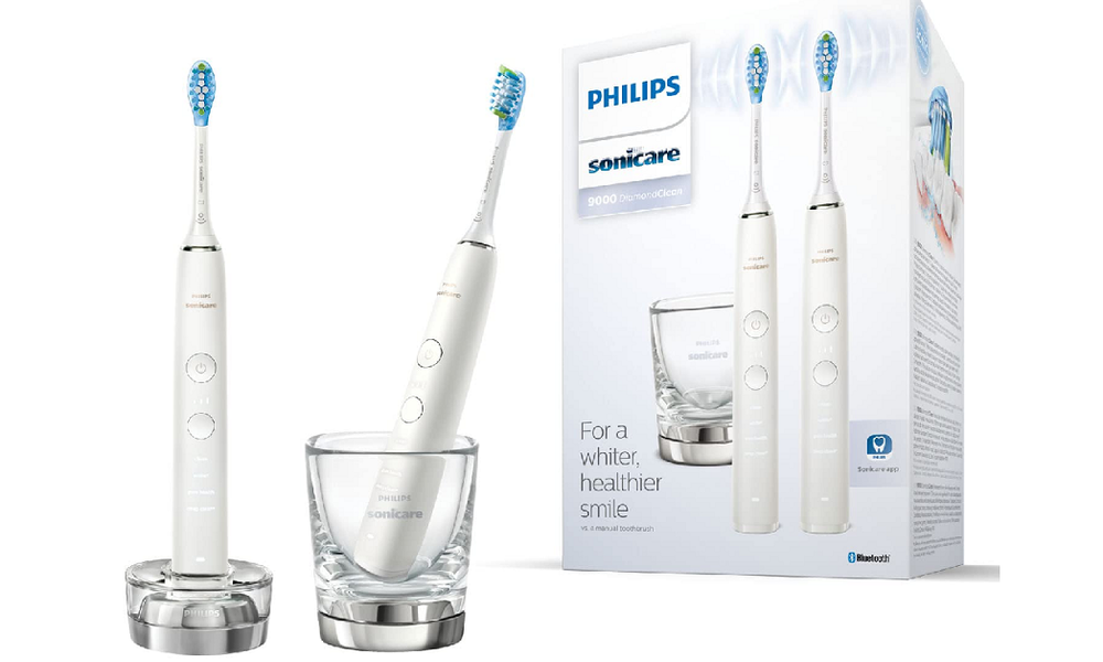 Zwei elektrische Schallzahnbürsten von Philips mit Ladebasis und Glas | © Amazon
