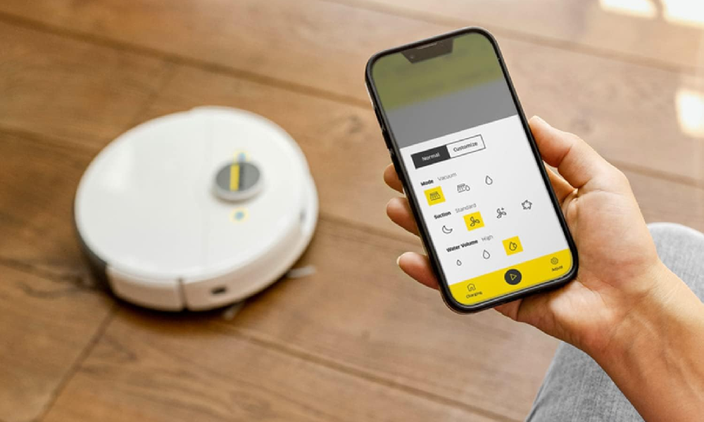 Kärcher Saugroboter, daneben ein Handy mit der Kärcher-App | © Amazon