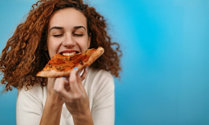 Frau isst Pizza | © Getty Images / StefaNikolic