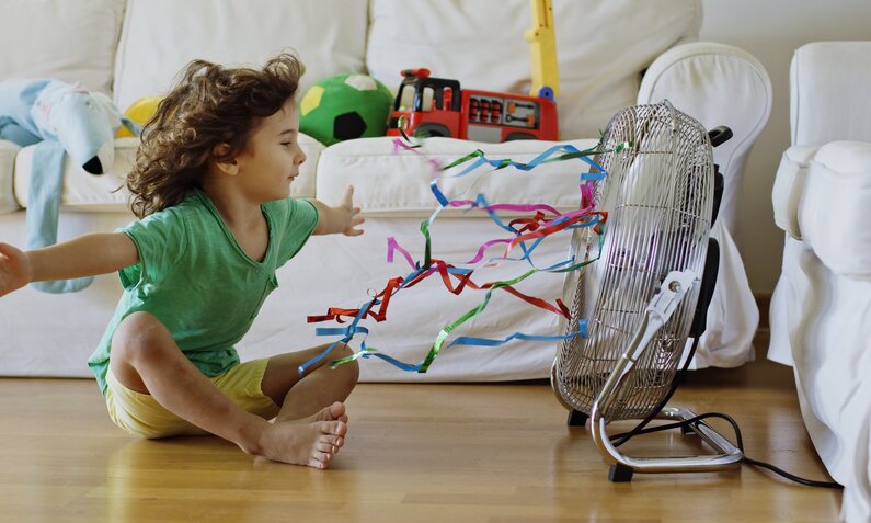 Kind vor Ventilator sitzend | © Getty Images / Thanasis Zovoilis