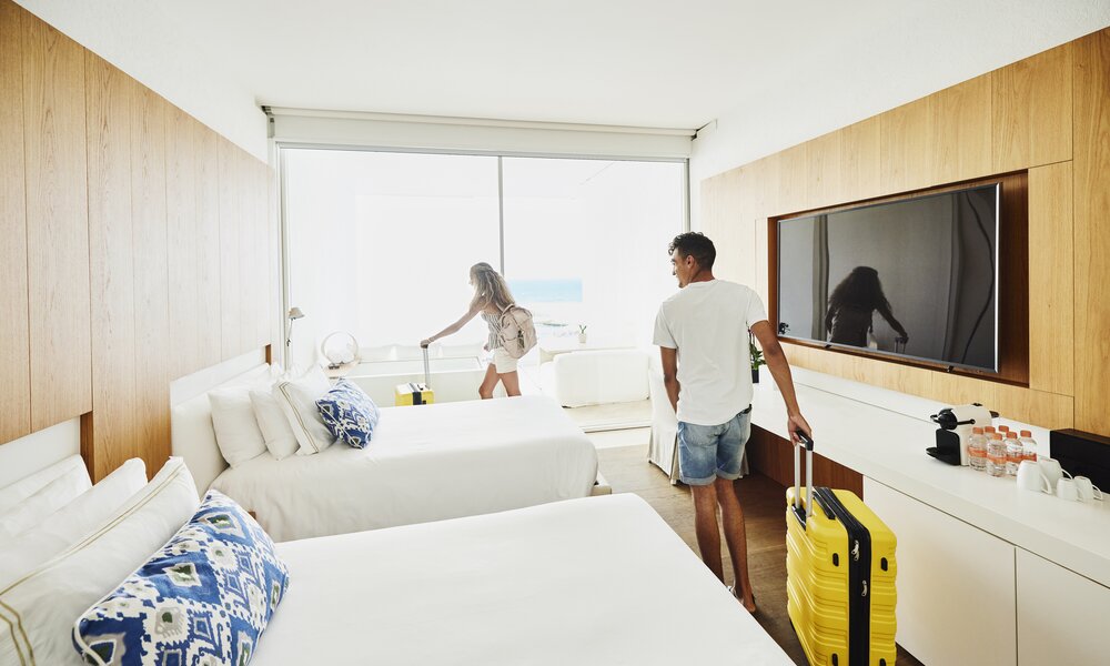 Ein Pärchen checkt ins Hotelzimmer ein.  | ©  Getty Images / Thomas Barwick