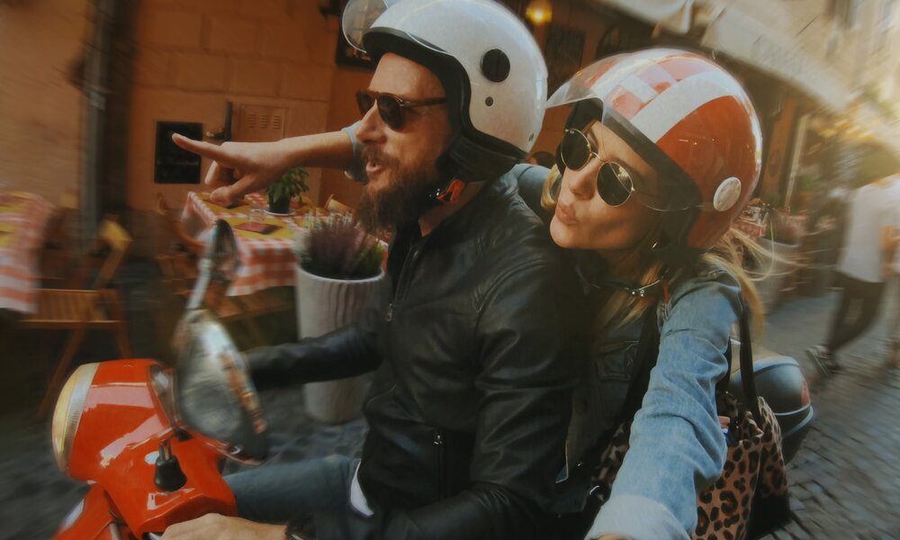 Ein Pärchen fährt mit einer Vespa durch Rom  | ©  Getty Images / piola666