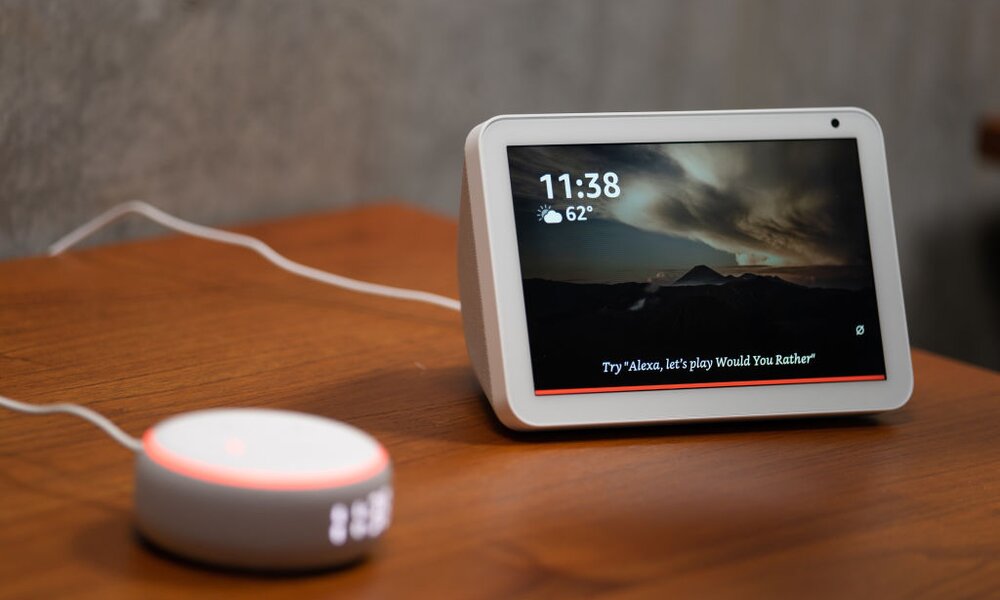 Das mit Bildschrim ausgestattete Gerät Echo Show steht rechts neben einer Echo-Box von Amazon. Beide Geräte arbeiten mit der Sprachassistentin Alexa zusammen. | © Getty Images/Bloomberg