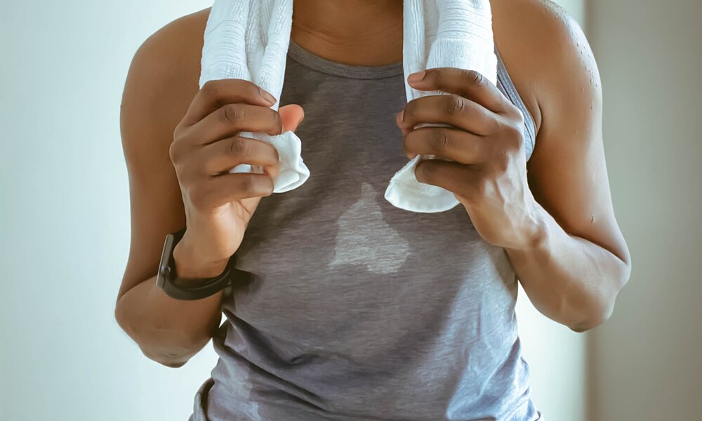 Torso mit Handtuch um den Hals. Das Tanktop ist vollgeschwitzt. | ©  Getty Images / Grace Cary