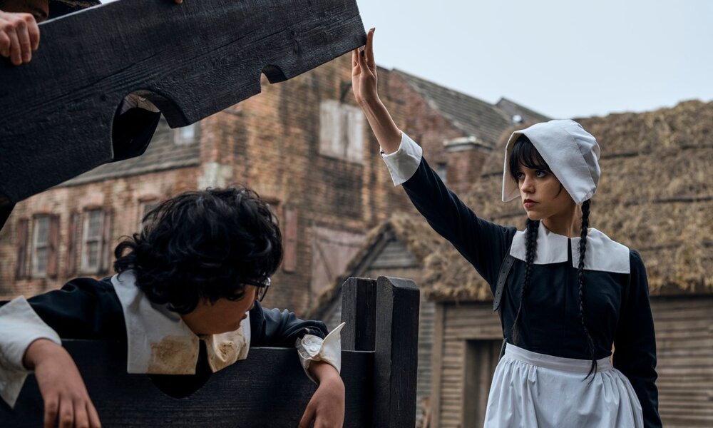 Wednesday befreit einen Jungen vom Pranger und trägt dabei die Kleidung puritanischer Einwanderer aus England. | © Netflix