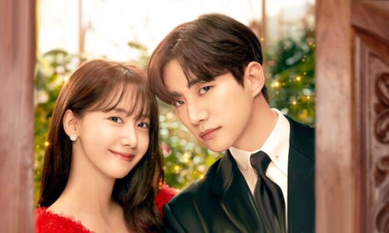 Im Yoon-ah und Lee Jun-Ho, die Stars der südkoreanischen Netflix-Serie "King the Land" sind hier in einer Paar-Porträtaufnahme zu sehen. Sie stehen in einem Türrahmen und blicken zum Betrachter. Sie lächelt, er nicht.  | © Netflix