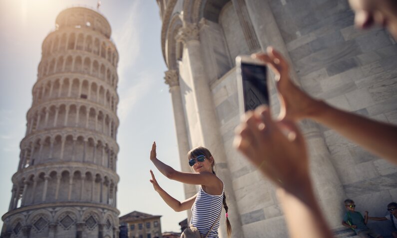 Frau posiert für ein Foto am schiefen Turm von Pisa | ©  Getty Images / Imgorthand