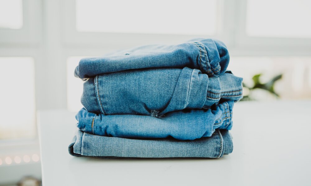 Ein Stapel blauer Jeans liegt auf einem Tisch  | ©  Getty Images / Carol Yepes