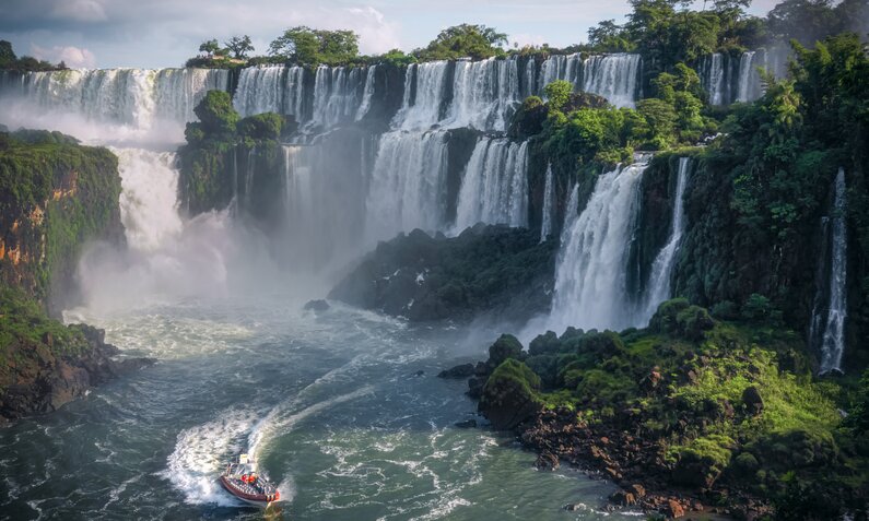 Eine Kulisse von rauschenden Wasserfällen, davor ein Boot | ©  Getty Images / Mekdet