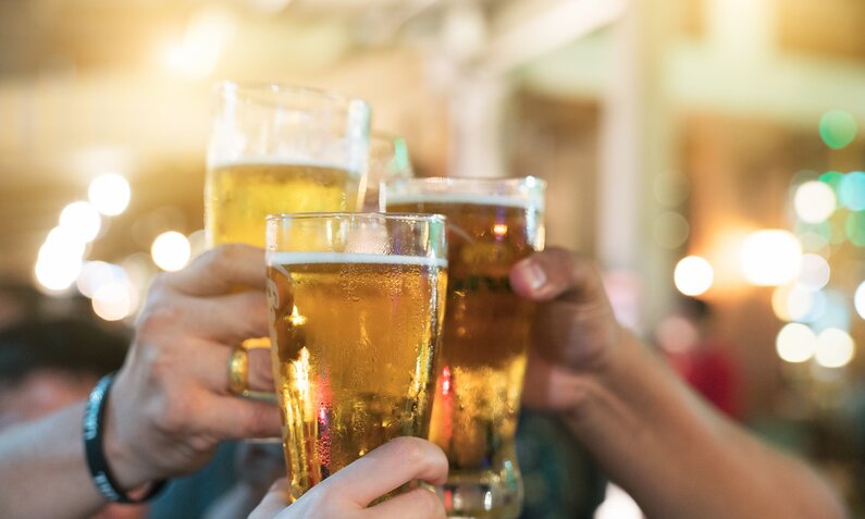 Hände, die in einer Bar mit Bier anstoßen | ©  Getty Images / Witthaya Prasongsin