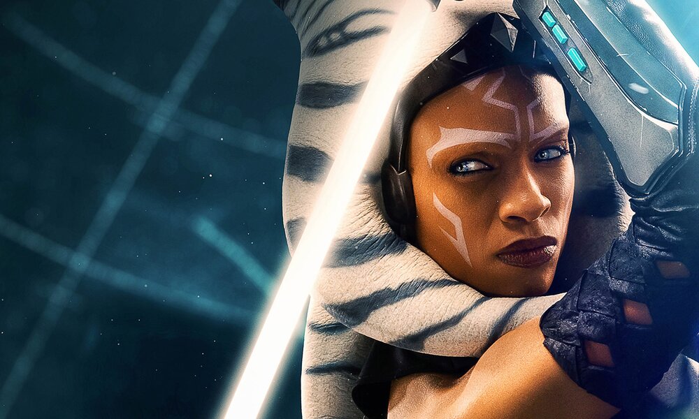 Rosario Dawson als jedi Ahsoka in der neuen "Star Wars"-Serie "Ahsoka". Auf dem Plakatausschnitt ist Ahsokas Gesicht in Nahaufnahme zu sehen und das aktive Lichtschwert, das sie in den über ihrem Kopf erhobenen Händen hält. | © Disney+