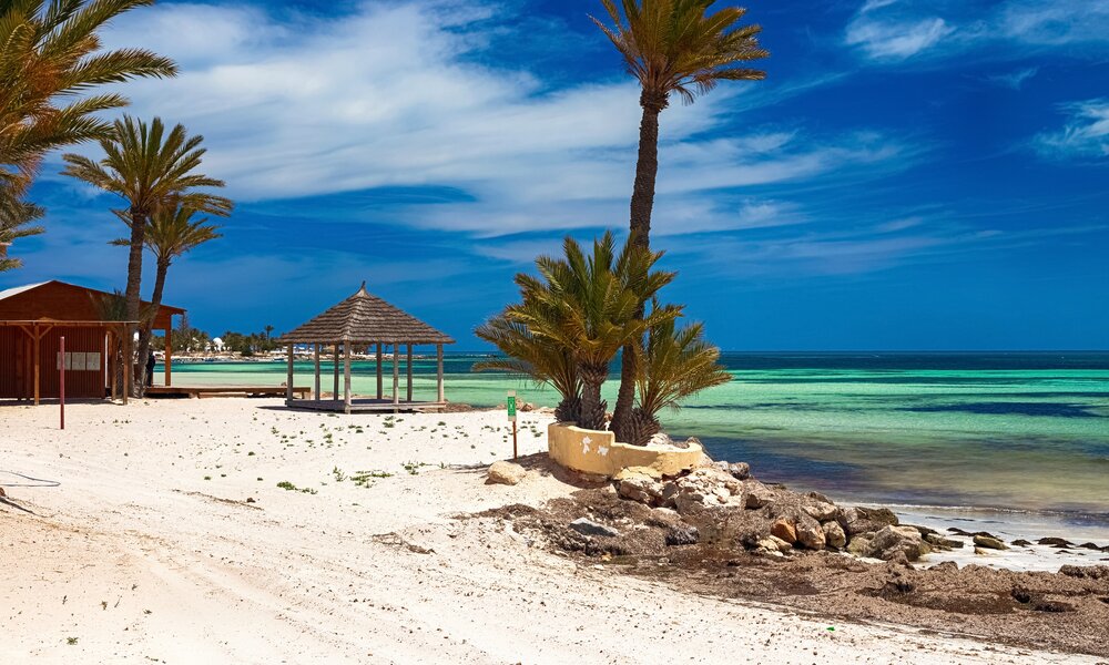 Der Strand von Djerba mit weißem Sand und Palmen  | ©  Getty Images / Natalia Babok