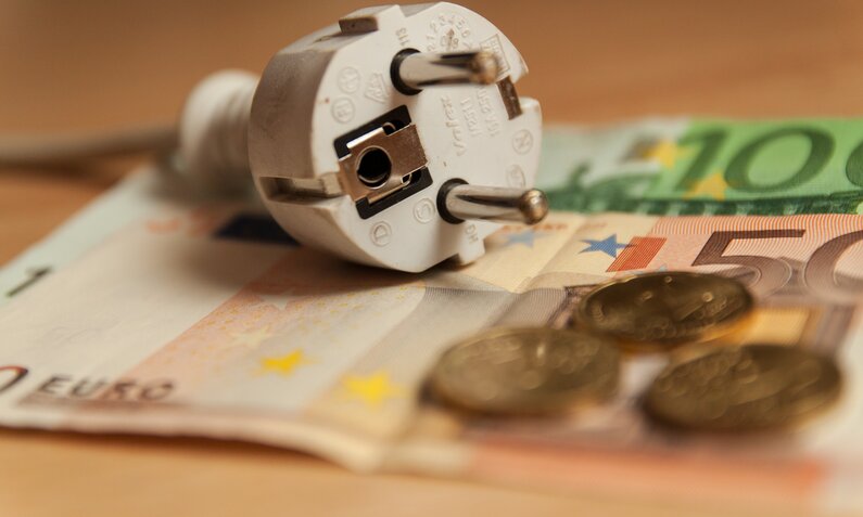 Ein Stecker liegt auf einem Haufen voller Euro-Scheine  | ©  Getty Images / Christina Reichl Photography