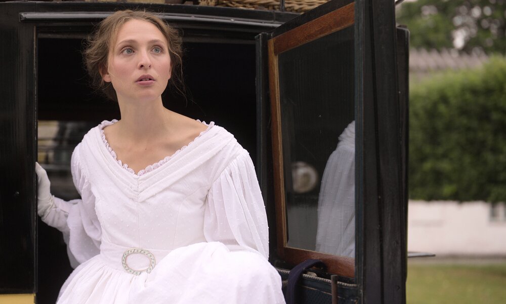Alice Bier Zanden steigt als Ehrengard im gleichnamigen Netflix-Film in ein prächziges weißes Kleid gekleidet aus einer Kutsche | © Netflix