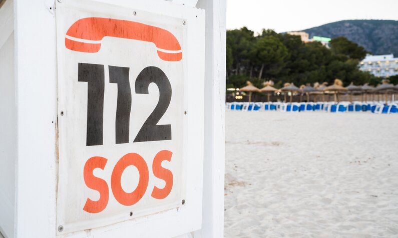 SOS 112 Schild an einem Strand | ©  Getty Images / Alberto Case