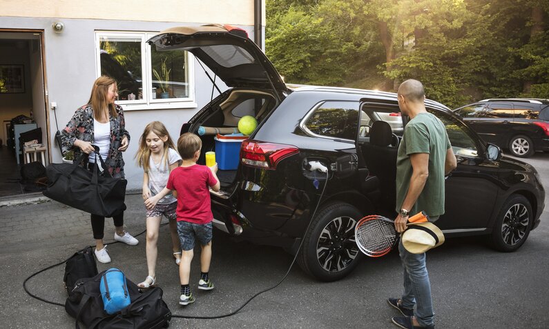 Familie packt Elektroauto für Reise | ©  Getty Images / Maskot