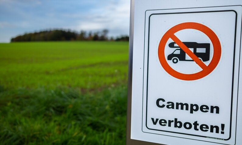  Camping verboten Schild vor Wiese | ©  Getty Images / David Taljat