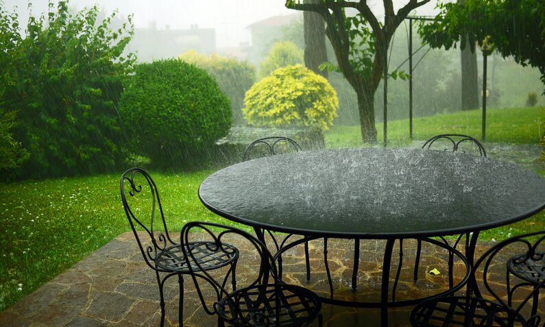  Starker Regen prasselt auf einen Gartentisch  | ©  Getty Images / Rosmarie Wirz